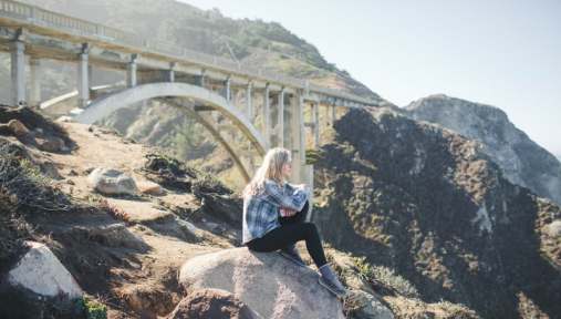 girl thinking with bridge in background